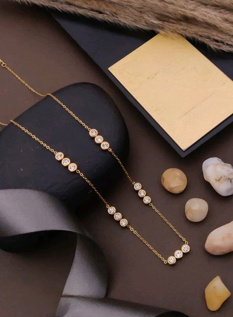 Gold necklace with pearls on a dark surface with stones
