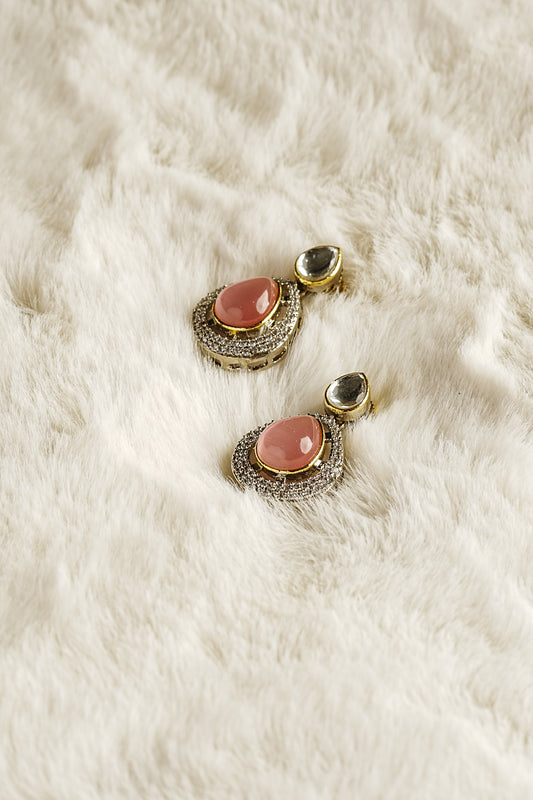 Pair of earrings with pink stones on a white fur surface